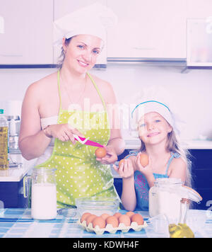 Lächelnde Frau und kleinen Tochter in Gap Vorbereitung Omelette Stockfoto