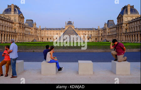 Touristen entspannen vor dem Louvre in Paris, mit einem Touristen die sich als Thinkert Stockfoto