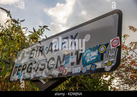 Footbll Aufkleber auf den Sir Alex Ferguson Weise Straßenschild in der Nähe von Old Trafford Fußball Stadion. Stockfoto