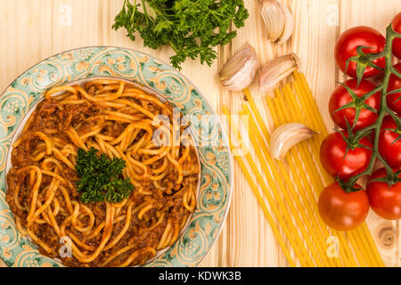 Italienische Art spaghetti bolognese Essen mit einem reichhaltigen Rindfleisch Sauce auf einem hellem Kiefernholz Hintergrund Stockfoto