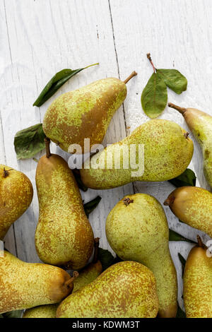 Abate Fetel Birnen mit Blättern auf weiß lackiertes Holz von oben. Platz für Text. Stockfoto