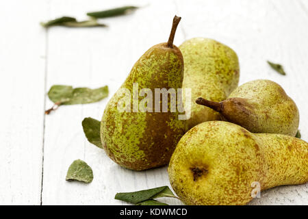 Vier Abate Fetel Birnen mit Blättern auf weiß lackiertes Holz. Stockfoto