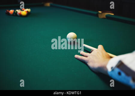 Amerikanisches Billard. Mann spielt Billard, Snooker. Player Vorbereitung zu schießen, schlagen die cue Ball. Stockfoto