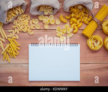 Italienische Lebensmittel Konzept und Menü Design. verschiedene Nudelsorten Winkelstück Makkaroni, Farfalle, Rigatoni, gnocco Sardo in Hanf sack Säcke auf Braun woode Stockfoto
