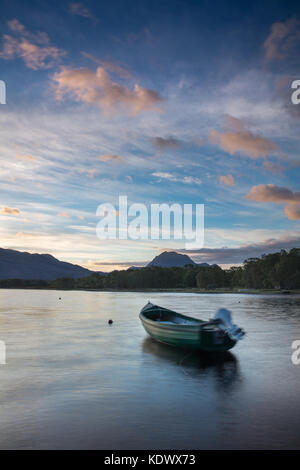 Breaking Dawn über ein Boot vertäut am Loch Maree, mit Slioch jenseits, Wester Ross, Schottland Stockfoto