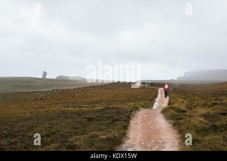 Walker am Fußweg zur Alten Mann von Hoy (sichtbar nach oben am Horizont) auf einer trostlosen regnerischen Tag, Hoy, Orkney Inseln, Schottland, Großbritannien Stockfoto