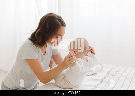 Mutter, Kind auf einem weißen Hintergrund zu sitzen Stockfoto