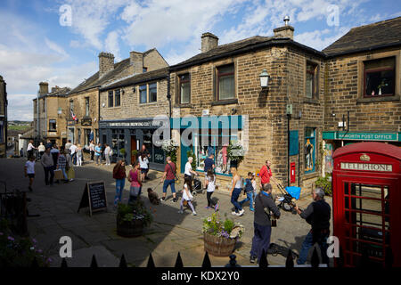 Pennines Dorf, Haworth in West Yorkshire, England. terrassierten Häuser und Geschäfte auf der steilen Straße Stockfoto