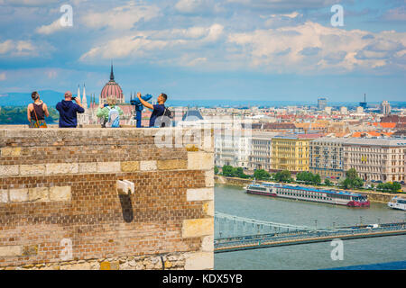 Budapest Städtetourismus, Ansicht von Touristen, die den Königspalast auf dem Var-Hügel besuchen und Fotos von Budapest von einem Wall hoch über der Stadt, Ungarn, machen. Stockfoto
