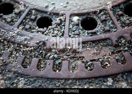 Rostigem Eisen Mannloch ist in Asphalt Fahrbahn mit einem großen Abstand an der Oberseite im Sommer Saison gesetzt. close-up Stockfoto