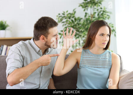 Wütend Paar kämpfen auf einer Couch zu Hause sitzen Stockfoto