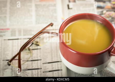 Stapel Zeitung auf Holz- Hintergrund mit Tasse Kaffee und Gläser Stockfoto