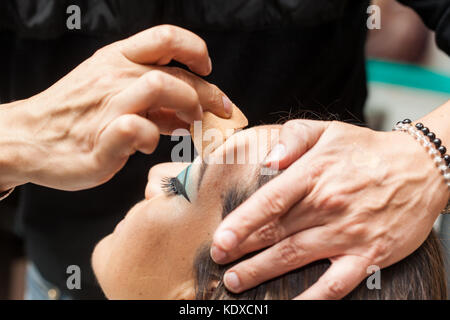 Make-up-Artist, die Stiftung mit einem Schwamm, der zu einer weißen Frau Stockfoto