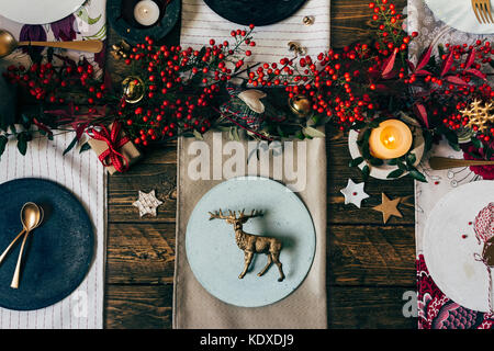 Urlaub Gold Gedeck, lustige Weihnachten Tabelle mit Ornamenten und natürlichen Beeren, auf Holztisch, Overhead schießen Stockfoto