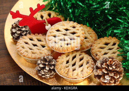 Weihnachten Mince Pies auf ein goldenes Schild mit rotem Rentier auf ein Holz Hintergrund Stockfoto