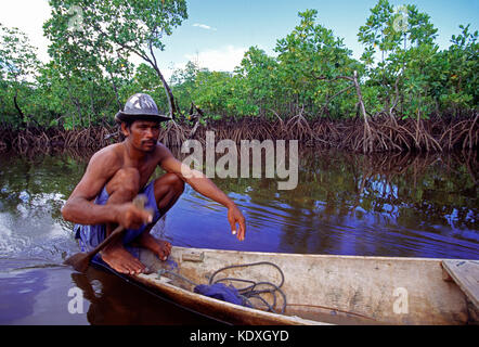 Indonesien. Sulawesi. Sama-Bajau Menschen. Mann im Kanu paddeln durch die Mangroven. Stockfoto