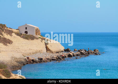 Meer, felsige Küste und Kirche. - Porto Torres, Italien Stockfoto