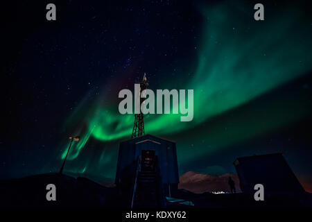 Grüne Wellen von Aurora Borealis mit leuchtenden Sterne über die Berge und Radio Tower, Nuuk, Grönland Stockfoto