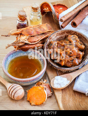 Hausgemachte Hautpflege und Körperpeeling mit natürlichen Zutaten Tamarind, Honig, Himalaya Salz, Kurkuma und Zimt auf Holz- Hintergrund. Stockfoto