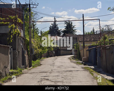 Schmale Straße mit Schlaglöchern durch das Dorf Velistsikhe in Georgien, Zugang zu den Nodari Weinkeller Stockfoto