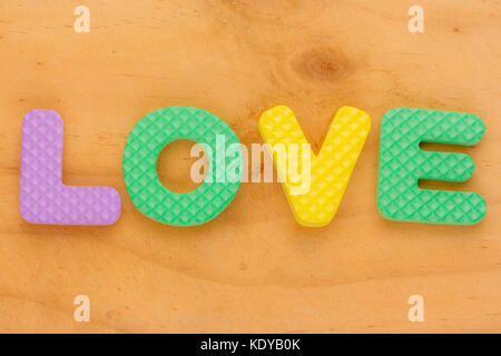 Schaumstoff Buchstaben bilden Wort Liebe auf Holz Hintergrund Stockfoto
