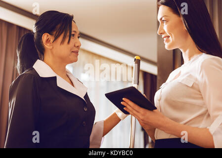 Freundliche Zimmermädchen sprechen mit ihrem Gast Stockfoto
