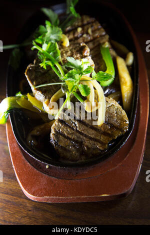 Gegrilltes Rindfleisch Steak serviert mit gebratenen Gemüse und gekrönt mit Koriander. Das Gericht ist ein Beispiel der Fusion-küche. Stockfoto