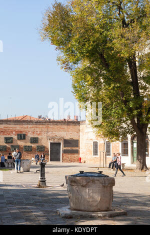 Campo De Gheto Novo und der Holocaust Gedenkstätte, Cannaregio, Venice, Italien mit dem alten Brunnen oder Pozzo im Vordergrund. Stockfoto