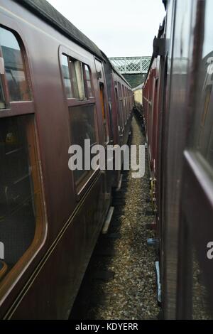 Ansicht zwischen zwei Reihen von Vintage Waggons im Bahnhof poppy North Norfolk line Stockfoto