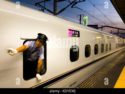 Zugbegleiter durch das Fenster der N700 Shinkansen von Himeji zu Osaka-Shi Station - Himeji, Hyogo Präfektur Kansai Region, Insel Honshu, Japan Stockfoto