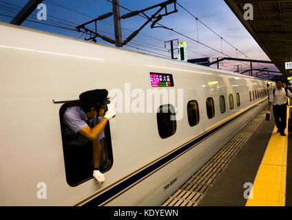 Zugbegleiter durch das Fenster der N700 Shinkansen von Himeji zu Osaka-Shi Station - Himeji, Hyogo Präfektur Kansai Region, Insel Honshu, Japan Stockfoto