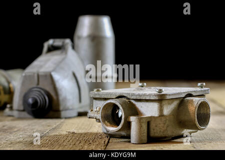 Alte Stecker und Buchse Hochspannung. Alte elektrische Zubehör. Holztisch, schwarzer Hintergrund Stockfoto