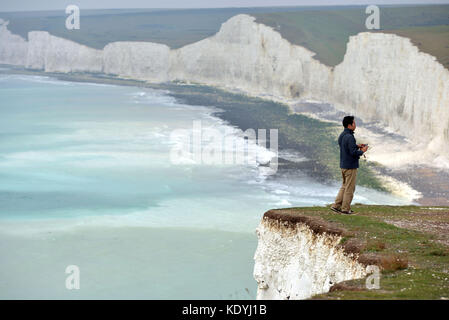 Touristen ihre Leben riskieren für selfies auf die bröckelnden Kreidefelsen am Birling Gap, in der Nähe der berühmten Sieben Schwestern, East Sussex. Stockfoto