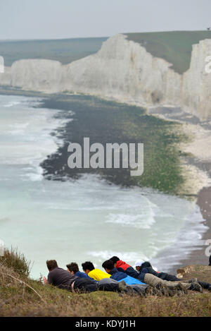 Touristen ihre Leben riskieren für selfies auf die bröckelnden Kreidefelsen am Birling Gap, in der Nähe der berühmten Sieben Schwestern, East Sussex. Stockfoto