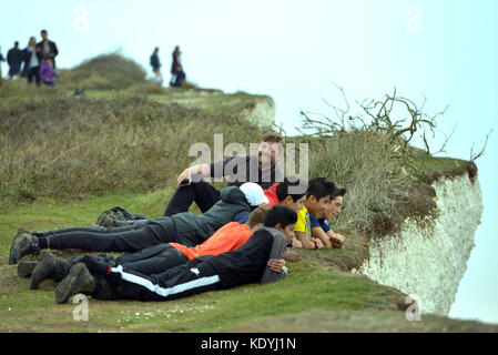 Touristen ihre Leben riskieren für selfies auf die bröckelnden Kreidefelsen am Birling Gap, in der Nähe der berühmten Sieben Schwestern, East Sussex. Stockfoto