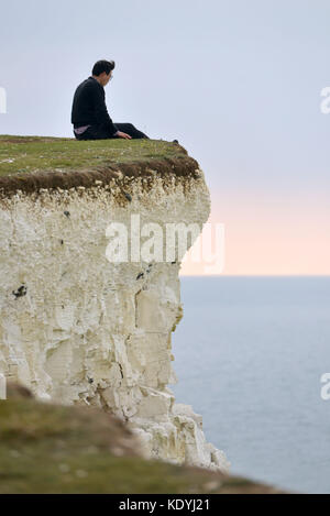 Touristen ihre Leben riskieren für selfies auf die bröckelnden Kreidefelsen am Birling Gap, in der Nähe der berühmten Sieben Schwestern, East Sussex. Stockfoto