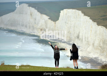 Touristen ihre Leben riskieren für selfies auf die bröckelnden Kreidefelsen am Birling Gap, in der Nähe der berühmten Sieben Schwestern, East Sussex. Stockfoto