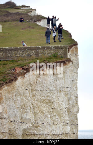 Touristen ihre Leben riskieren für selfies auf die bröckelnden Kreidefelsen am Birling Gap, in der Nähe der berühmten Sieben Schwestern, East Sussex. Stockfoto