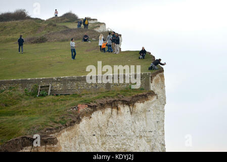 Touristen ihre Leben riskieren für selfies auf die bröckelnden Kreidefelsen am Birling Gap, in der Nähe der berühmten Sieben Schwestern, East Sussex. Stockfoto