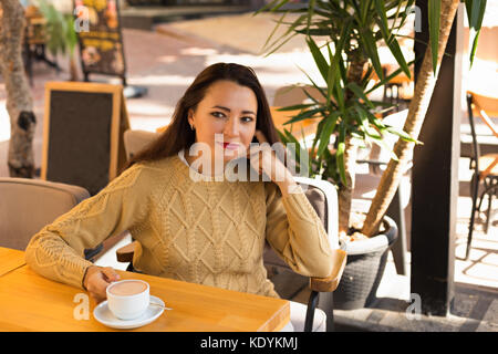 Frauen in warmen Pullover in Outdoor Cafe trinken heiße Schokolade Stockfoto