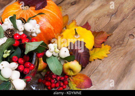 Thanksgiving oder Hintergrund mit snowberry und Vogelbeeren, Kürbis, Äpfel, Kegel und gelben Squash fallen Stockfoto