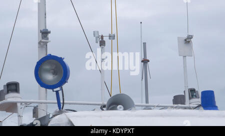 Hausgemachte Windfahne, eine Vorrichtung zur Bestimmung der Windrichtung auf dem Schiff. Die Spitze eines Segelschiffes steht vor einem blauen Himmel Stockfoto