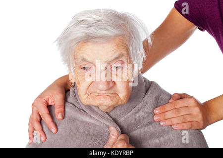 Ältere kranke Frau auf isoliert von einer warmen Decke Betreuer der helfende Hände fallen Stockfoto