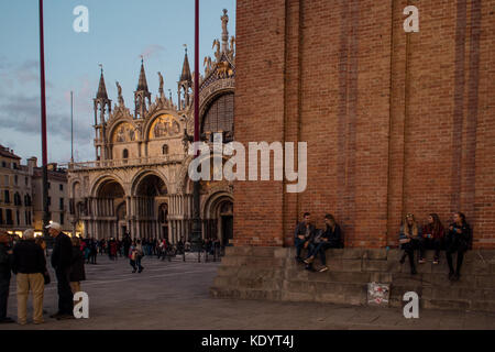 Venedig, Italien - 6. Oktober 2017: Basilica di San Marco, Menschen auf der Piazza San Marco entfernt sitzen, Abend Stockfoto