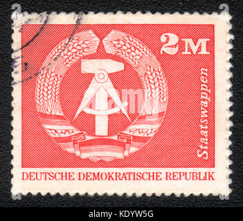 Eine in der DDR gedruckte Briefmarke zeigt das Emblem der DDR, um 1975 Stockfoto