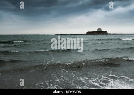 Von st cwyfan Kirche isoliert auf das horison der Irischen See als Sturm ophelia Landfall auf Anglesey, North Wales, UK macht Stockfoto