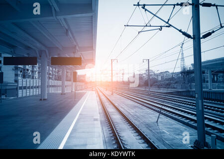 High speed Personenzug auf Titel mit Motion blur Effekt bei Sonnenuntergang. Bahnhof in der Ukraine Stockfoto