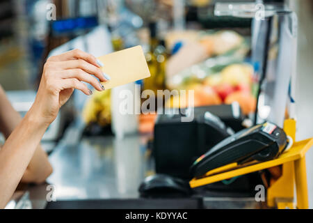 Shop Assistant holding Kreditkarte Stockfoto
