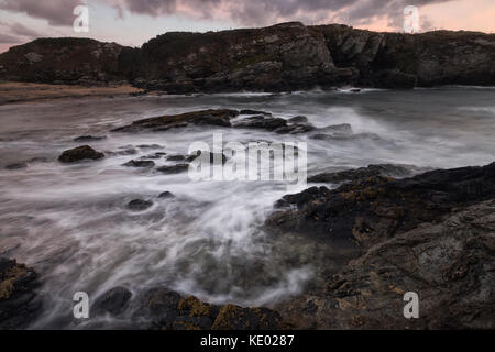 Lange exposre Treaddur bay Bild von Küste und Meer bei Sonnenuntergang, Anglesey, Wales, Großbritannien Stockfoto