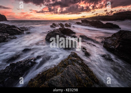 Lange exposre Treaddur bay Bild von Küste und Meer bei Sonnenuntergang, Anglesey, Wales, Großbritannien Stockfoto